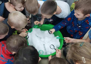Dzieci oglądają śnieg przez lupy