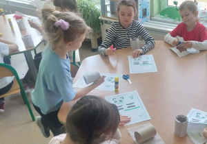 Dzieci wykonują pandy z rolek po papierze toaletowym
