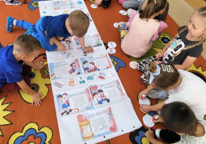 Chłopcy tworzą plakat pierwszej pomocy.