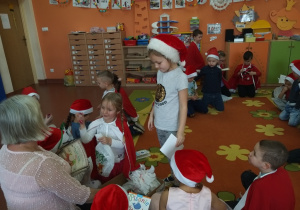 Dzieci z grupy ,,Wiewiórki odbierają prezenty pozostawione przez Świętego Mikołaja