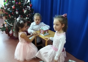 dzieci podziwiają świąteczny domek