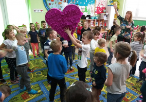 dzieci tańczą i podają sobie ogromne serce