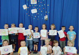 dzieci pokazują ilustracje swoich kropek
