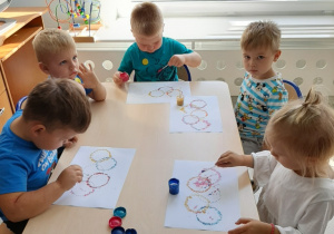 dzieci malują kropki farbami