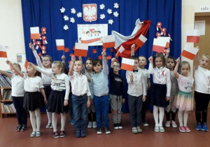 dzieci z grupy Wiewiórki prezentują własnoręcznie wykonane flagi Polski
