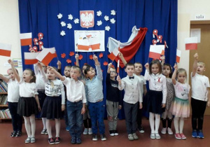 dzieci z grupy Wiewiórki prezentują własnoręcznie wykonane flagi Polski