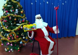 Mikołaj pokazuje prezent dla grupy-klocki lego