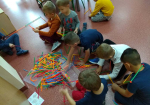 dzieci bawią się prezentem-patyczkami konstrukcyjnymi