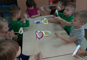 dzieci z grupy Rybki malują farbami styropianowe serduszka