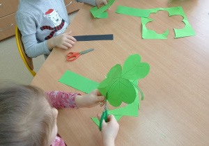 dzieci wycinają koniczynki z zielonego papieru
