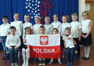 dzieci z grupy Wiewiórki trzymają polską flagę