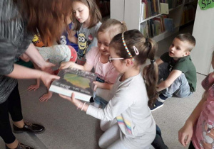 dzieci oglądają atlas Polski