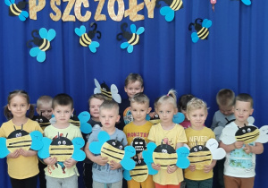 dzieci z grupy Rybki stoją pod napisem Dzień Pszczoły