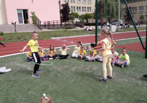 dzieci rywalizują na czas w kręceniu hula-hop