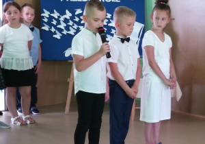 dwóch chłopców i dziewczynka recytują wiersze