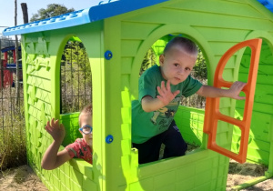 dzieci bawią się w plastikowym domku