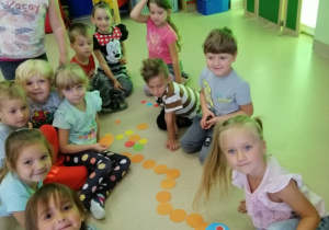 Dzieci prezentują ułożonego z kółeczek węża