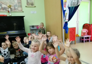 Grupa dzieci klaszcze w ręce do piosenki o przedszkolaczku