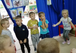 Dzieci wesoło tańczą w kółeczku.