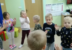 Grupa dzieci klaszcze w ręce do piosenki o przedszkolaczku