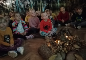 chłopcy i dziewczynki siedzą przy ognisku i słuchają opowieści z pradawnych czasów.