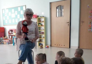 nauczycielka pokazuje dzieciom postać krasnala Hałabały