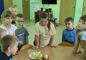 Dzieci z grupy Motyli oglądają owoce potrzebne do wykonania eksperymentu