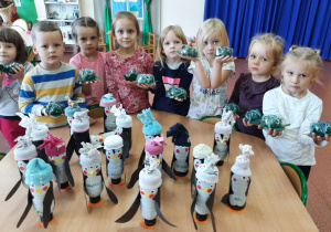 Dzieci prezentują wykonane pingwinki i żółwie z butelek PET