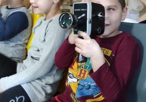 Chłopiec kręci film starą kamerą