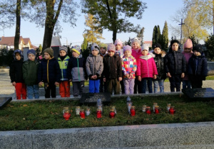 Dzieci zapalają znicze na Cmentarzu Wojennym
