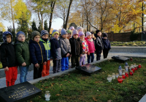 Dzieci zapalają znicze na Cmentarzu Wojennym