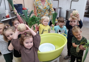dzieci trzymają w dłoniach różne warzywa