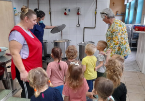 dzieci słuchają pani kucharki,która opowiada o swojej pracy