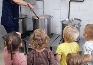 dzieci przyglądają się pracy pani kucharki
