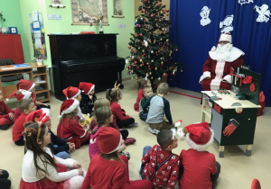 Dzieci śpiewają i rozmawiają z Mikołajem