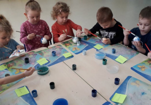 Dzieci z grupy Rybki malują bombki farbami