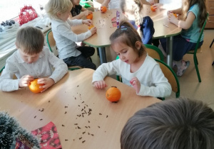 Dzieci dekorują pierniki cukrowymi mazakami.