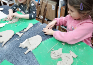 Dzieci ozdabiają gliniane koguciki