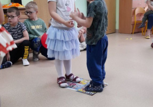 Dziewczynka z chłopcem przygotowują się do konkurencji-taniec na gazecie