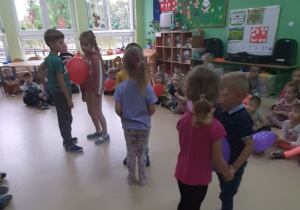 Dzieci tańczą trzymając balon brzuszkami