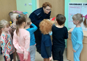 Przedszkolaki oglądają akcesoria niezbędne w pracy Policjanta