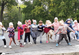 Przedszkolaki prezentują jesienny taniec w parku