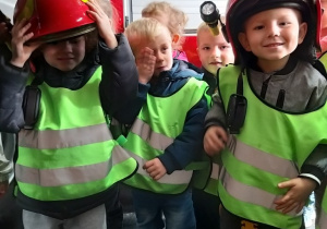 Dzieci przymierzają kaski strażackie