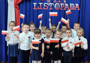 Dzieci z grupy "Wiewiórki" prezentują wykonane prace plastyczne - flagę Polski