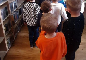 Dzieci oglądają biblioteczną wypożyczalnię książek