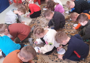 Dzieci rysują wzorki na papierowych bombkach