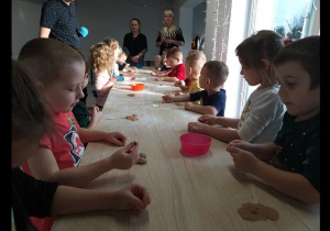 Dzieci ugniatają piernikowe ciasto