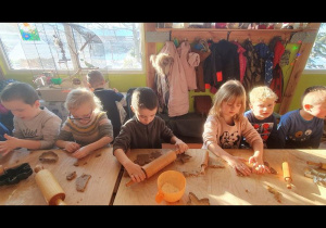 Dzieci wałkują ciasto na pierniki