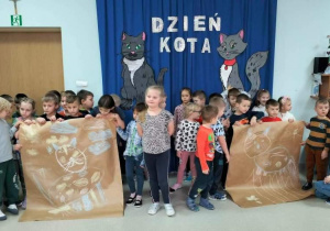 Przedszkolaki prezentują narysowane koty