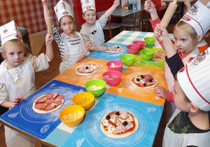 Dzieci prezentują wykonane pizze.